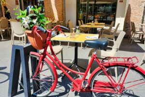 a red bicycle parked next to a yellow table